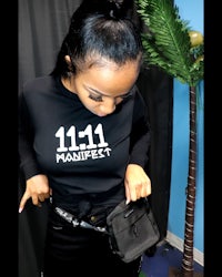 a woman wearing a black sweatshirt with the number 1111 on it